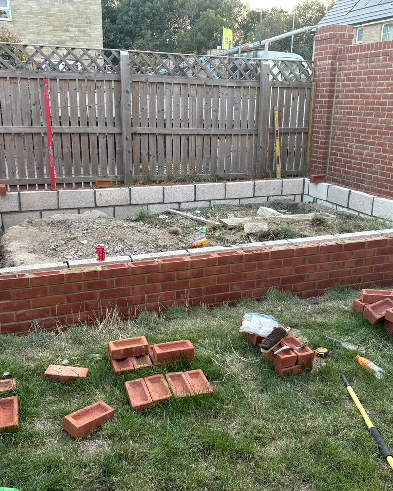 Brick and block footings built up around the edge of a garden base