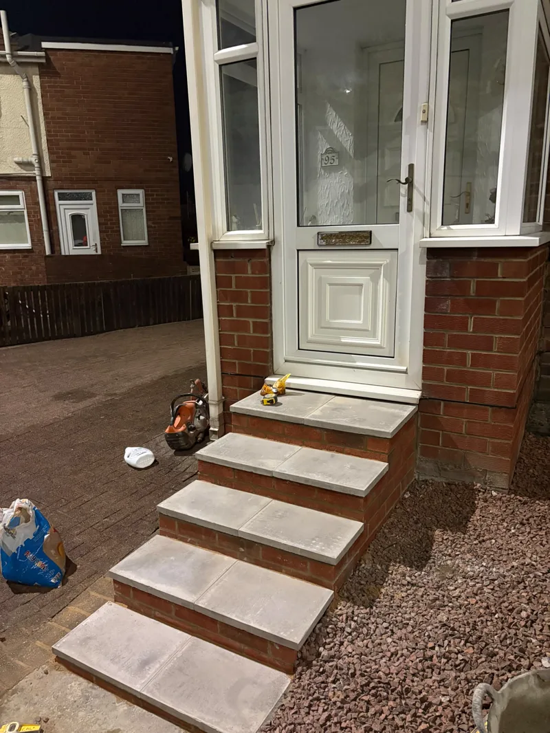 The same front entrance steps rebuilt in red brick with fresh paving-slab treads