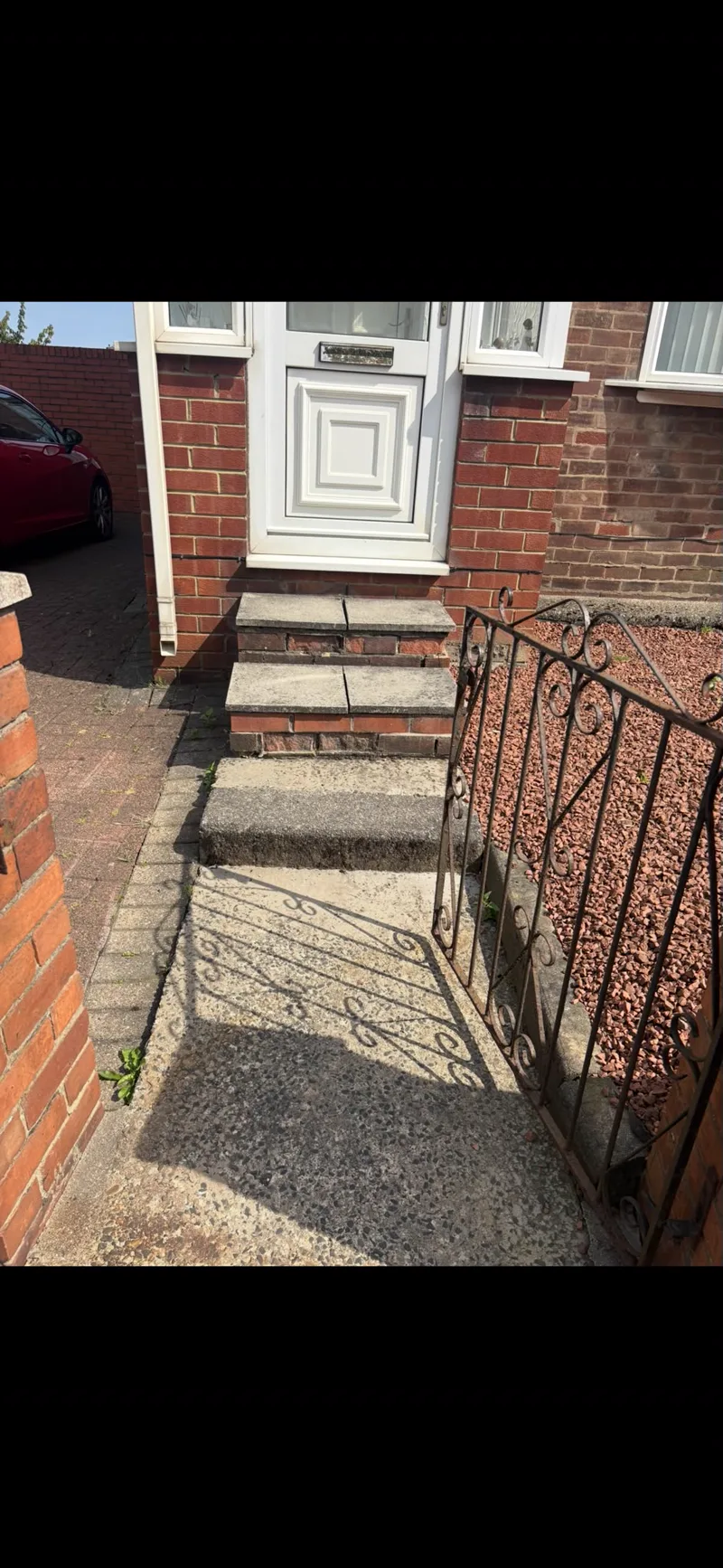 Worn front entrance steps with cracked concrete slab treads on crumbling brickwork before rebuilding