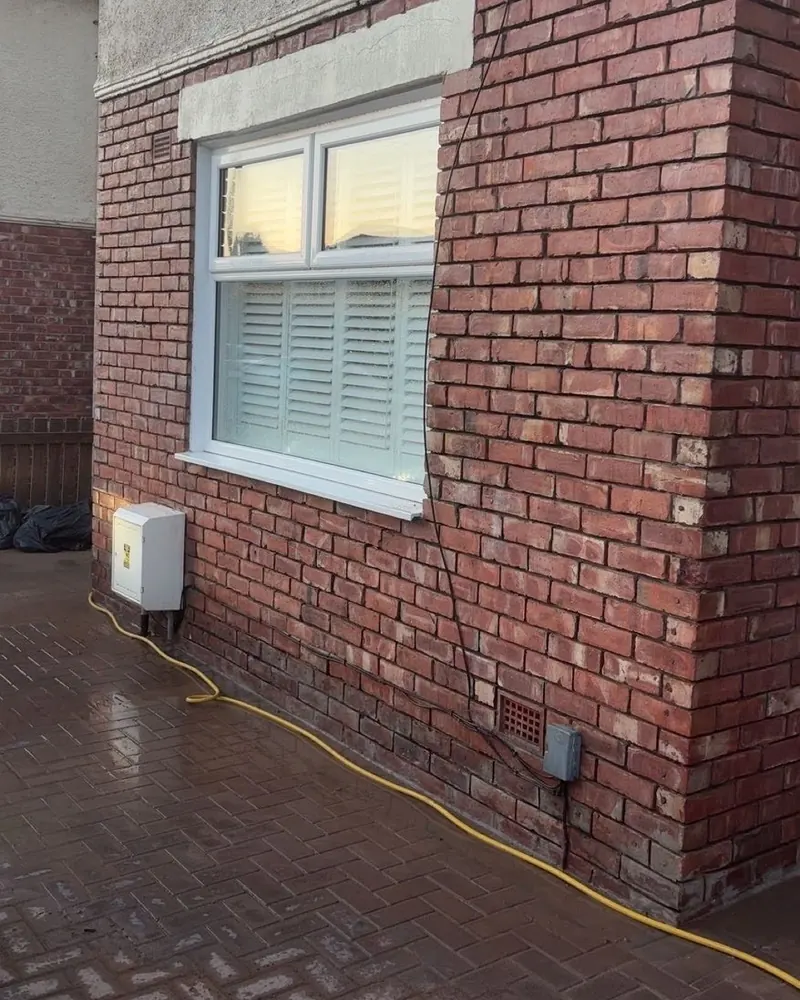 Finished red brickwork around a ground-floor window on the side of the house