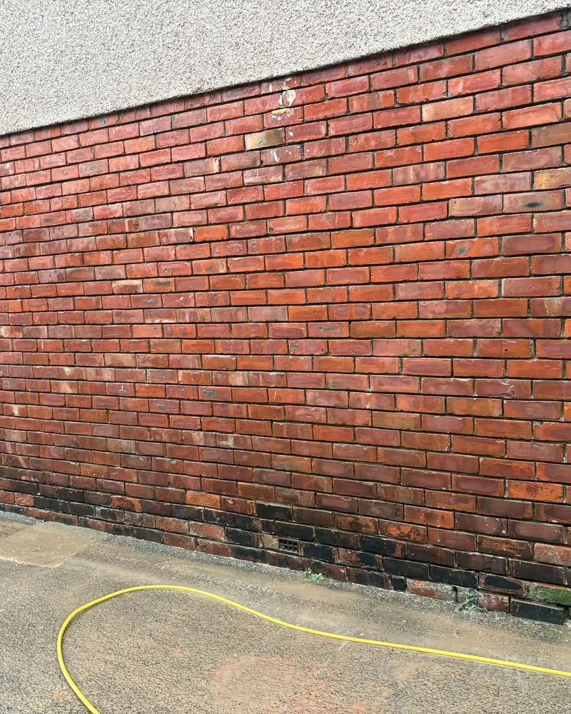 Brick gable wall with weathered, recessed mortar joints before repointing